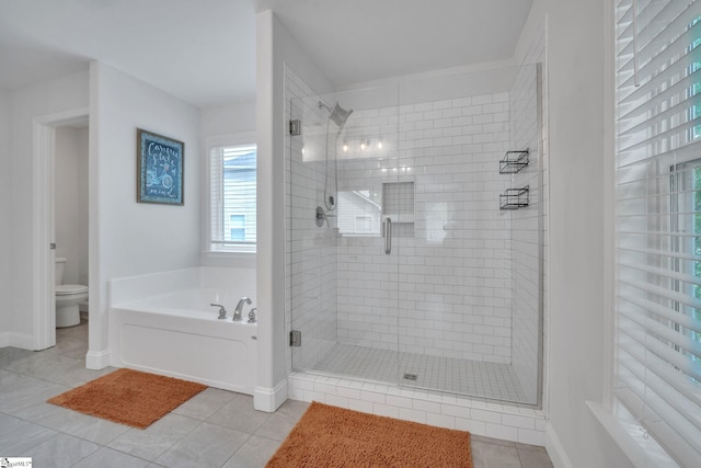 full bathroom featuring a bath, a stall shower, toilet, baseboards, and tile patterned flooring