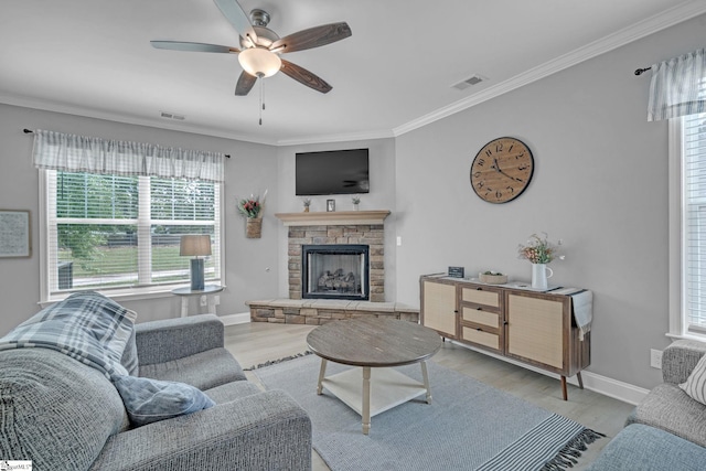 living area with crown molding, light wood-type flooring, visible vents, and a ceiling fan