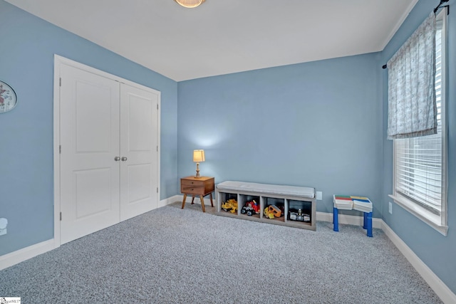 recreation room featuring baseboards and carpet