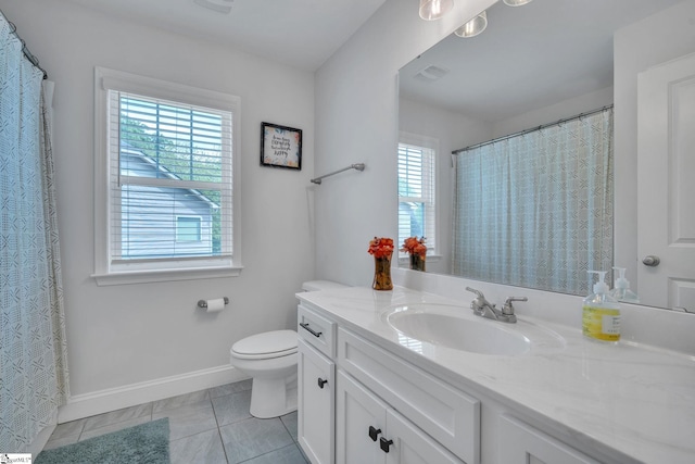 bathroom featuring toilet, baseboards, a healthy amount of sunlight, and tile patterned floors