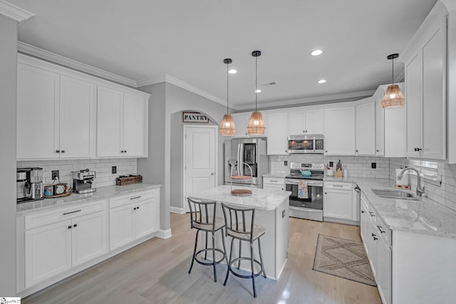 kitchen featuring tasteful backsplash, appliances with stainless steel finishes, white cabinetry, and a sink
