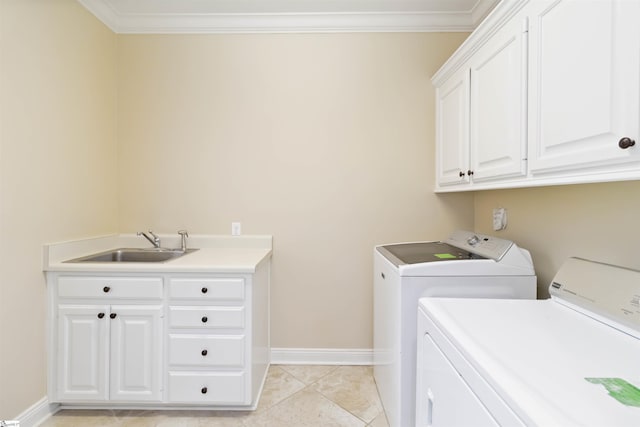 laundry room featuring a sink, washing machine and dryer, crown molding, baseboards, and cabinet space
