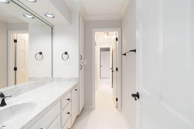 bathroom with baseboards, crown molding, vanity, and tile patterned floors