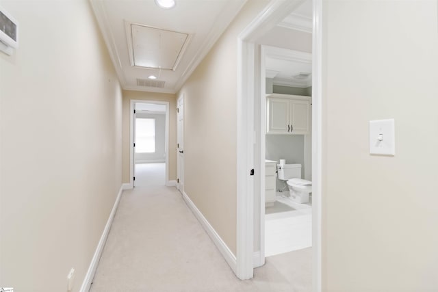 hallway with attic access, crown molding, baseboards, and recessed lighting