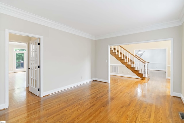 empty room with visible vents, crown molding, stairs, and a notable chandelier