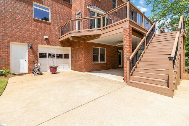 rear view of property featuring an attached garage, brick siding, driveway, and stairway