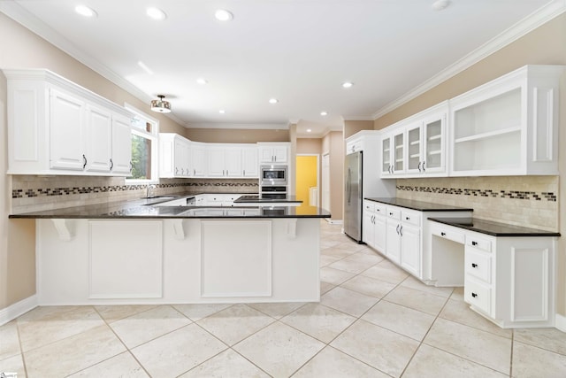 kitchen featuring a peninsula, dark countertops, appliances with stainless steel finishes, and decorative backsplash