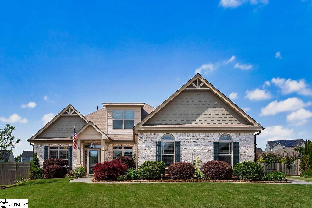craftsman house featuring fence, a front lawn, and brick siding