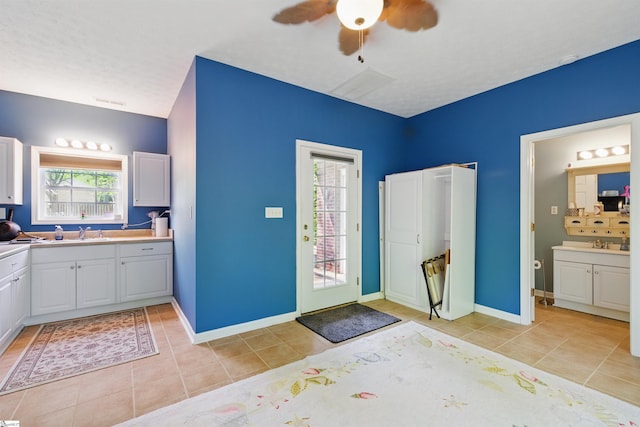 full bath with ceiling fan, a healthy amount of sunlight, tile patterned floors, and a sink