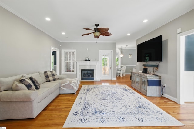 living area featuring recessed lighting, light wood-style floors, crown molding, baseboards, and ceiling fan