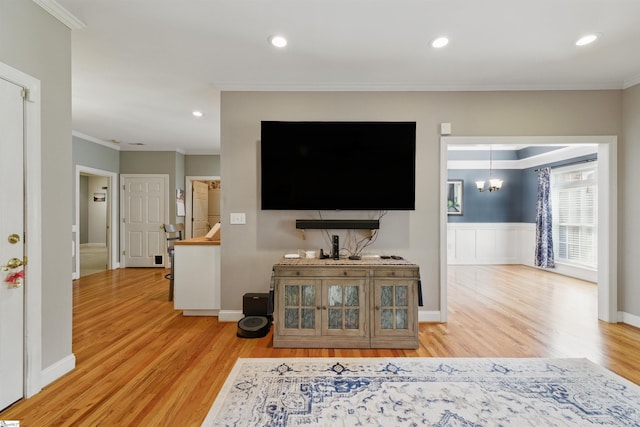 living area with light wood-type flooring, recessed lighting, a chandelier, and crown molding