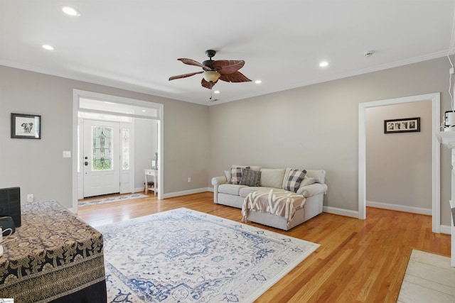 living room featuring baseboards, recessed lighting, light wood-style floors, a ceiling fan, and crown molding
