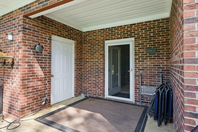 view of exterior entry with brick siding