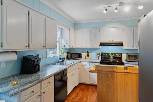 kitchen with a textured ceiling, a sink, a toaster, stainless steel appliances, and under cabinet range hood