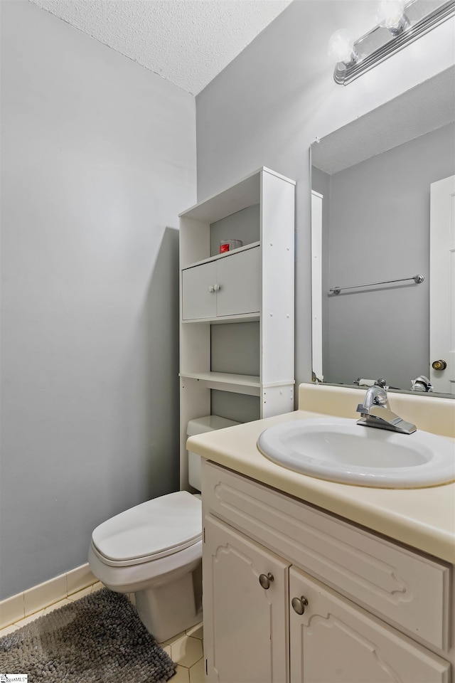 bathroom featuring a textured ceiling, tile patterned floors, vanity, and toilet