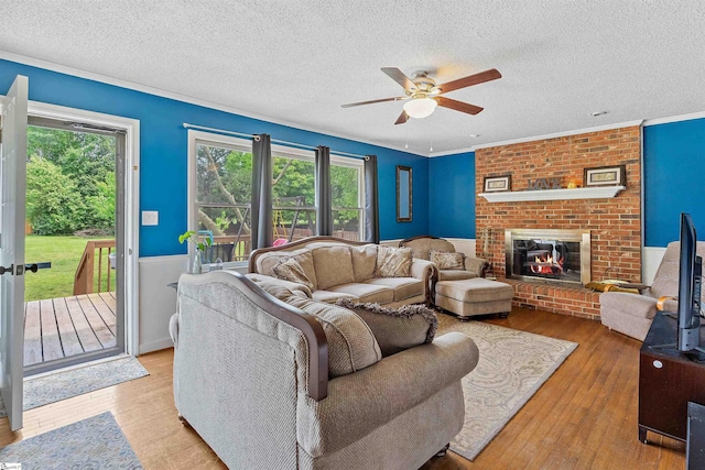 living room featuring light wood-type flooring, a healthy amount of sunlight, and a ceiling fan