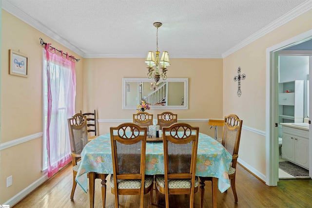 dining room with wood finished floors, a textured ceiling, and an inviting chandelier