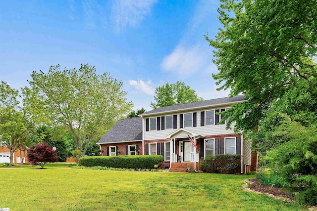view of front facade featuring brick siding and a front yard