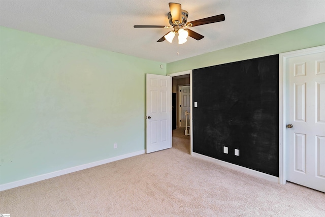 unfurnished bedroom with a ceiling fan, baseboards, and light colored carpet
