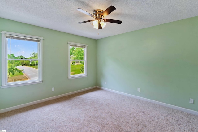 carpeted empty room featuring a ceiling fan, baseboards, and a textured ceiling