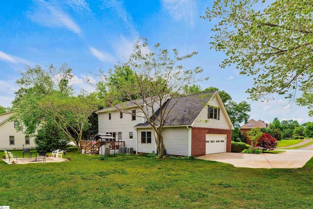 back of house featuring driveway, central AC, a garage, a deck, and a yard