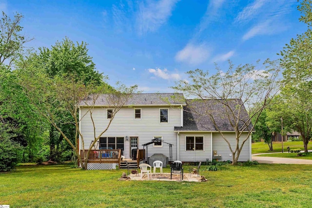 back of property featuring a yard, roof with shingles, a patio, and a deck