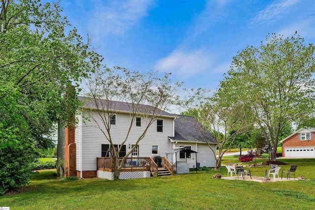 back of house with a wooden deck, a yard, and a detached garage