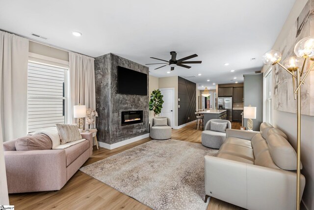 living area featuring a ceiling fan, visible vents, and light wood-style flooring