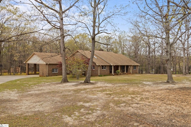 ranch-style home featuring a front yard, brick siding, an attached carport, and concrete driveway