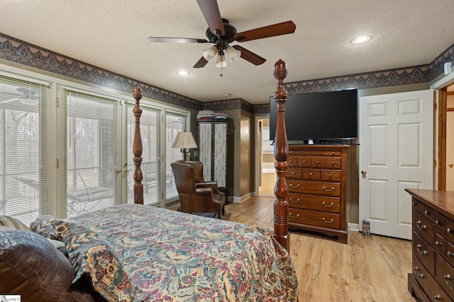 bedroom featuring light wood-style floors, a textured ceiling, baseboards, and multiple windows