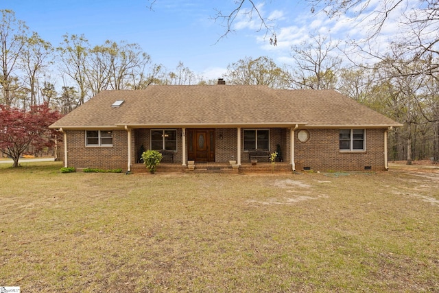ranch-style home with brick siding, a shingled roof, a front yard, and covered porch