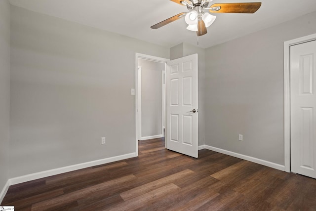unfurnished bedroom with a ceiling fan, baseboards, and dark wood-style flooring