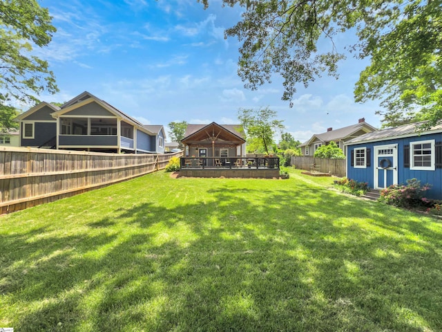 view of yard with a fenced backyard, an outdoor structure, and a sunroom