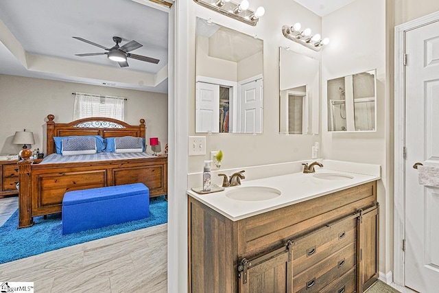 bathroom featuring double vanity, ceiling fan, ensuite bathroom, and a sink
