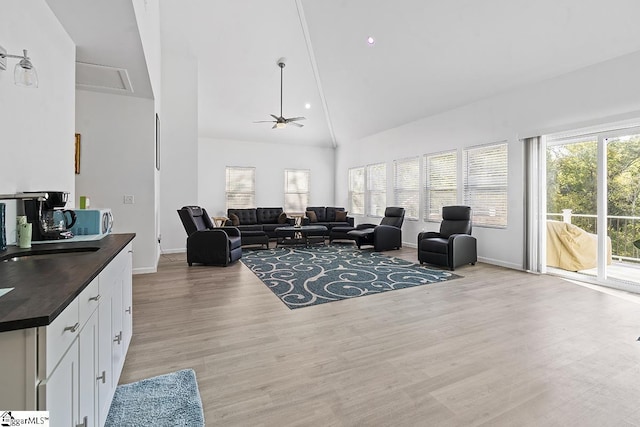 living room featuring high vaulted ceiling, baseboards, a ceiling fan, and light wood-style flooring