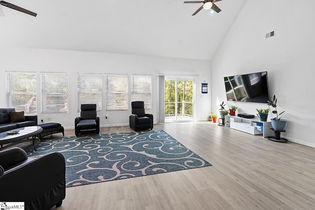 living area featuring high vaulted ceiling, wood finished floors, ceiling fan, baseboards, and visible vents