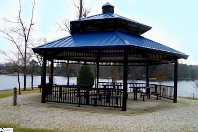 surrounding community with a gazebo and a water view