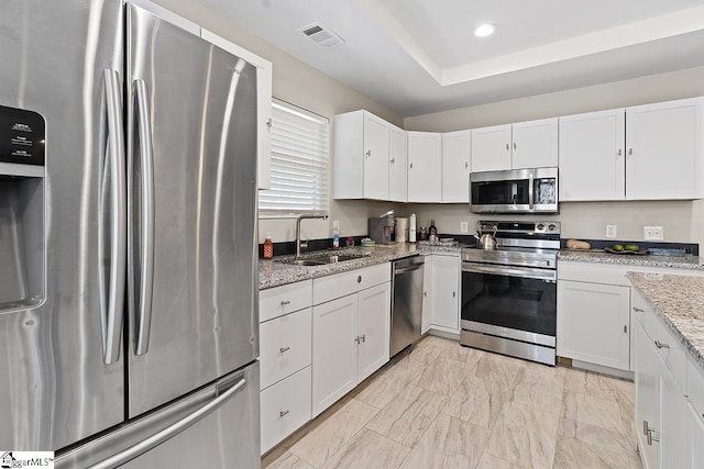 kitchen with marble finish floor, stainless steel appliances, visible vents, a sink, and white cabinetry