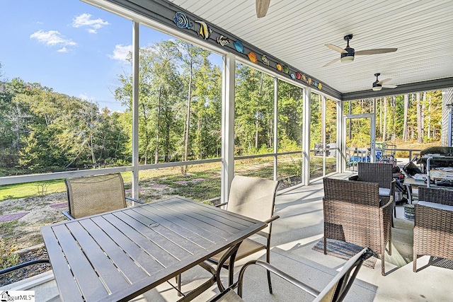 sunroom / solarium with outdoor dining space, a wealth of natural light, and ceiling fan