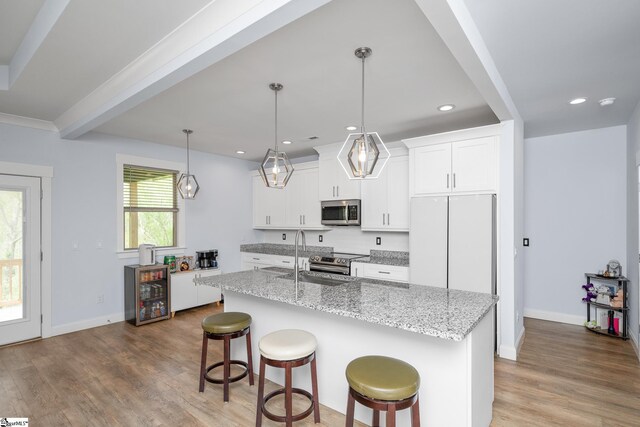885 Affirmed Dr, Boiling Springs, SC 29316 - kitchen featuring wood finished floors, a sink, stainless steel appliances, a center island with sink, and a kitchen bar