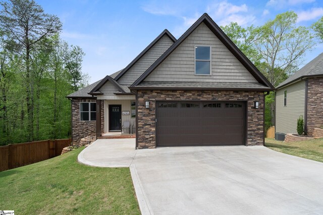 885 Affirmed Dr, Boiling Springs, SC 29316 - craftsman-style house featuring stone siding, a front lawn, concrete driveway, and fence