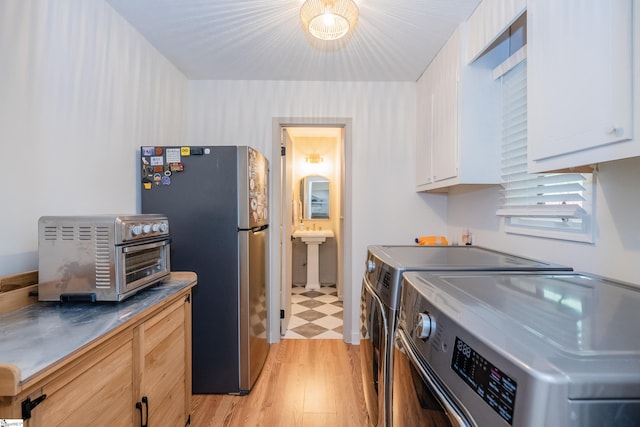 409 Freeman Bridge Rd, Marietta, SC 29661 - kitchen featuring washer and clothes dryer, stainless steel countertops, freestanding refrigerator, white cabinetry, and a sink