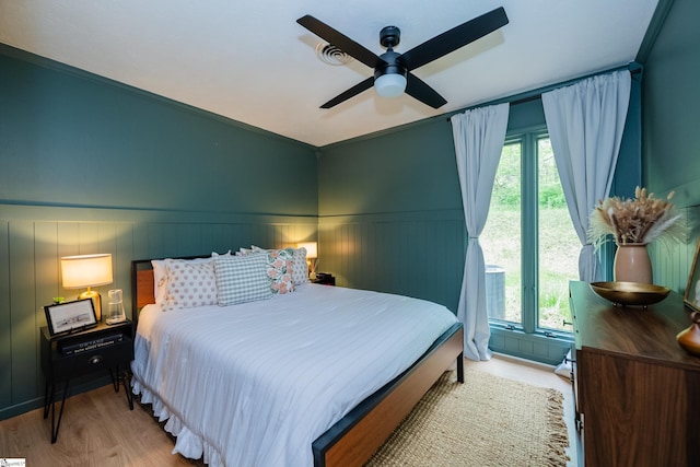 409 Freeman Bridge Rd, Marietta, SC 29661 - bedroom with multiple windows, a ceiling fan, wood finished floors, and a wainscoted wall