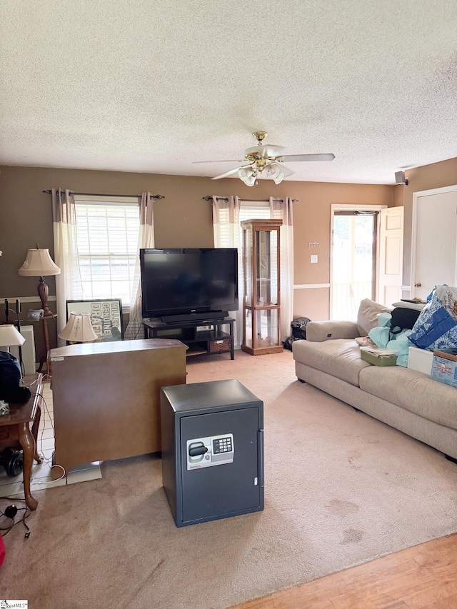 living room with a textured ceiling and ceiling fan