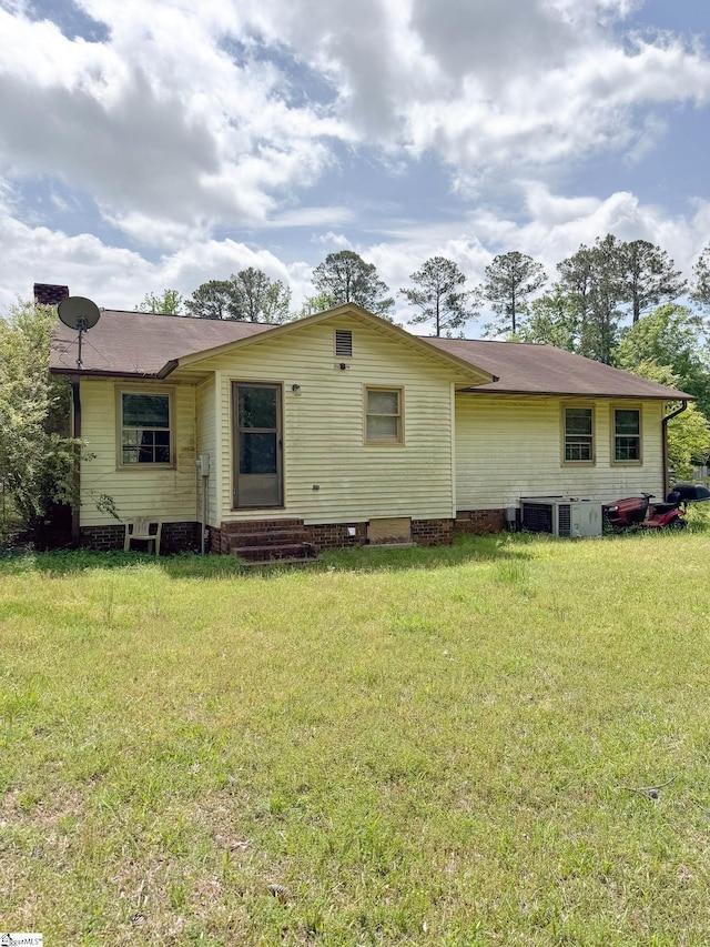 rear view of house featuring central air condition unit, crawl space, a yard, and entry steps