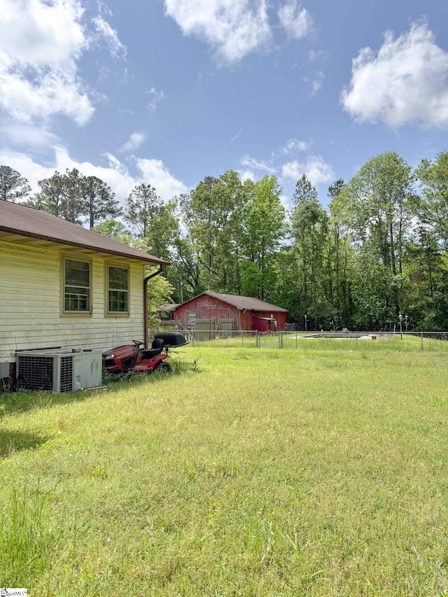 view of yard featuring fence and central AC