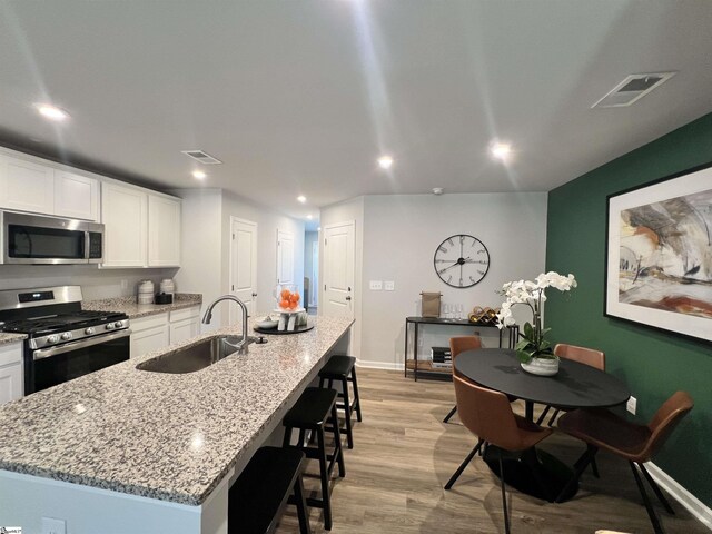 1236 Forestbrook Ln, Spartanburg, SC 29303 - kitchen with white cabinets, stainless steel appliances, visible vents, and a sink