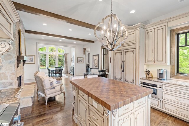 295 Chastain Hill Rd, Taylors, SC 29687 - kitchen with wooden counters, cream cabinetry, oven, beamed ceiling, and a notable chandelier