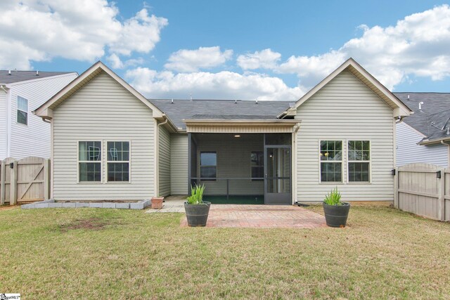 rear view of house featuring a lawn, a gate, a fenced backyard, and a patio area
