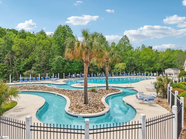 community pool featuring fence and a patio